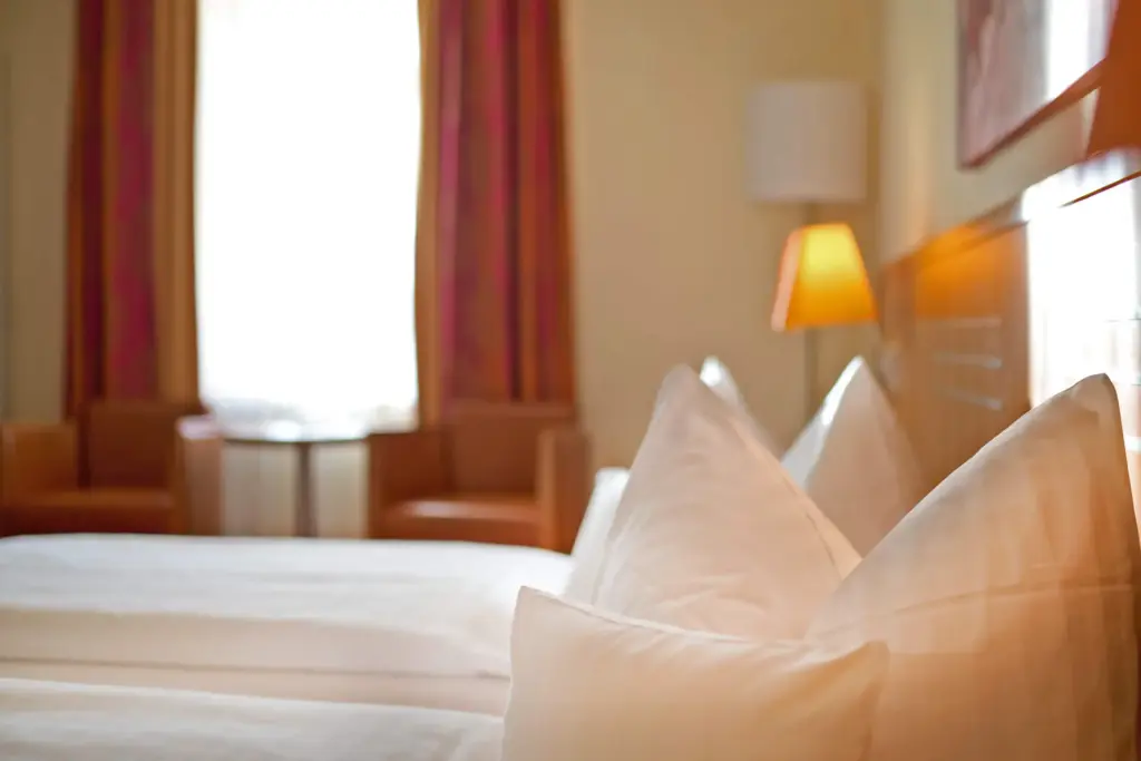 Hotelzimmer mit Bett und Nachttischlampe