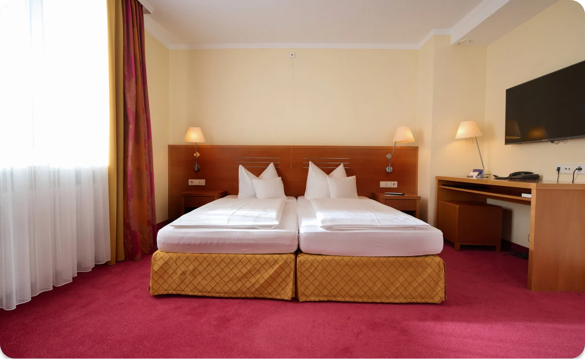 Hotelzimmer mit zwei Betten und Schreibtisch