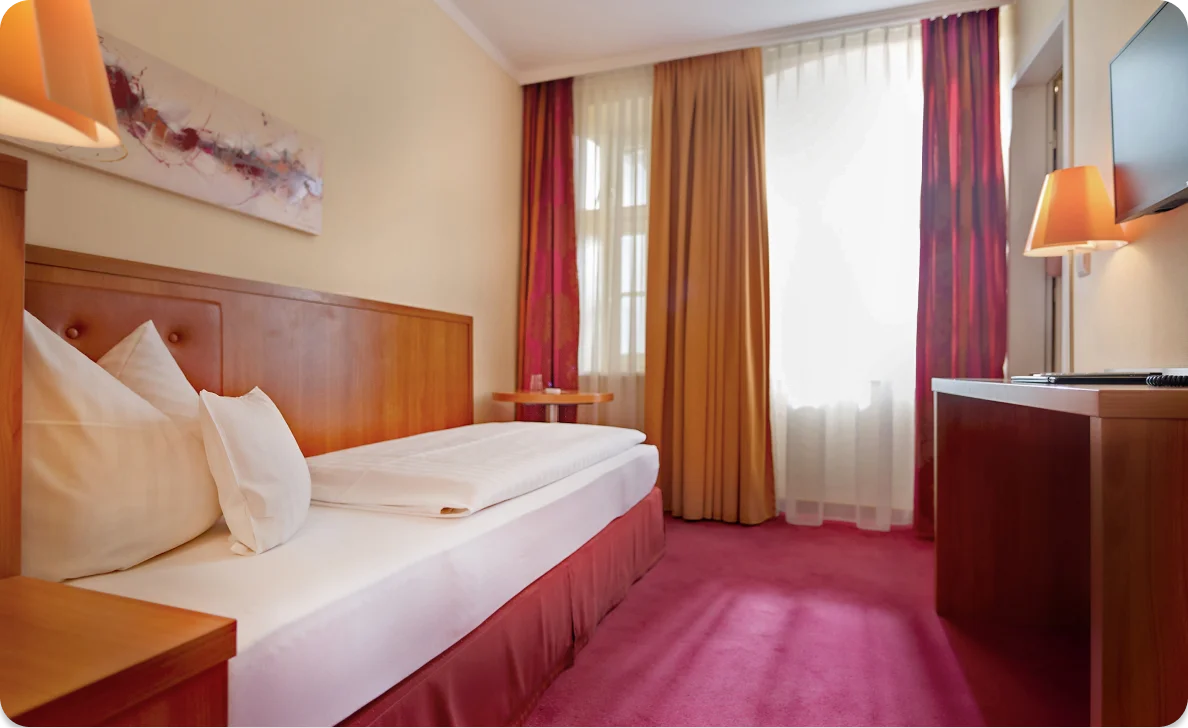 Hotelzimmer mit Bett und Schreibtisch