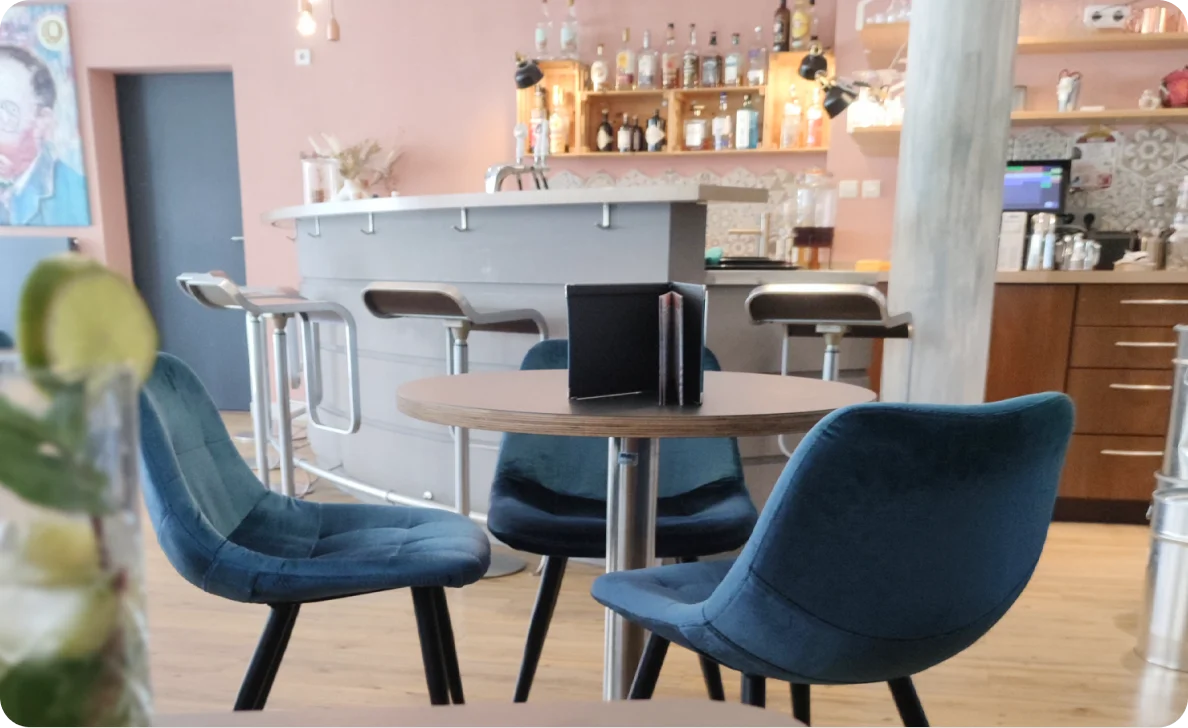 Modernes Café mit blauen Stühlen und Laptop auf Tisch